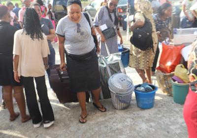 A Parent Helping Her Ward With Her Luggage Into The Hall Of Residence