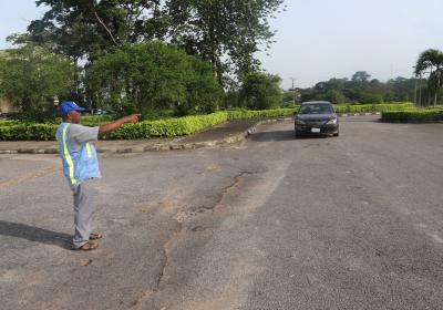 A Road Safety Member Directing An Incoming Vehicle